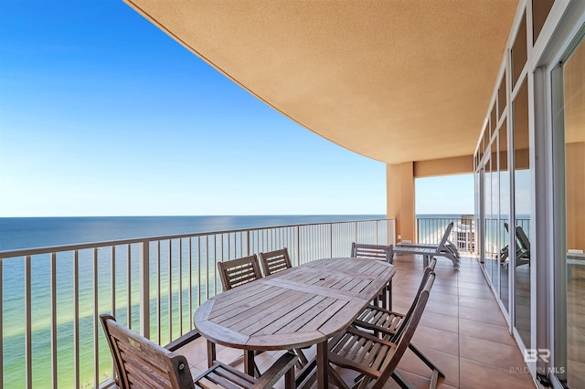 balcony featuring outdoor dining area and a water view