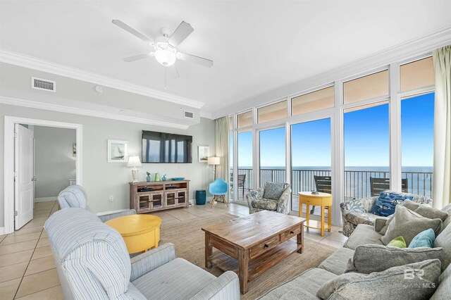 living room featuring visible vents, a water view, plenty of natural light, crown molding, and light tile patterned floors