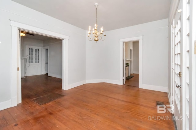 empty room featuring hardwood / wood-style floors and ceiling fan with notable chandelier