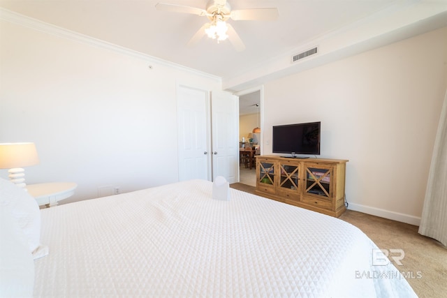 bedroom with ceiling fan, ornamental molding, and carpet