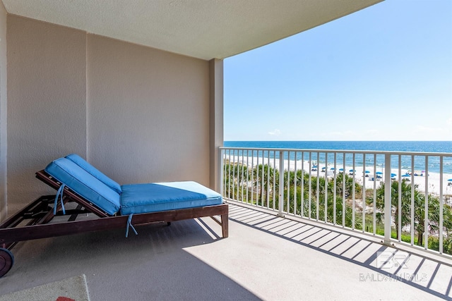 balcony with a water view and a beach view