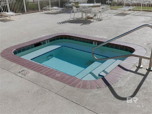 view of swimming pool featuring a hot tub and a patio area