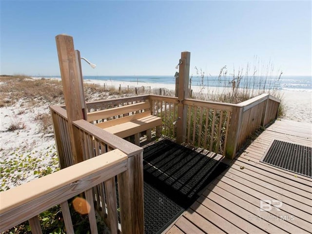 wooden deck with a beach view and a water view