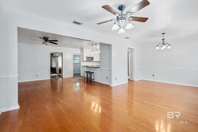 5175 W Somerset Dr, Mobile, AL 36619 - unfurnished living room featuring a ceiling fan, light wood-style flooring, a chandelier, and baseboards
