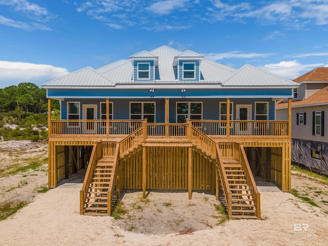 view of front of house with a carport, covered porch, metal roof, and stairway