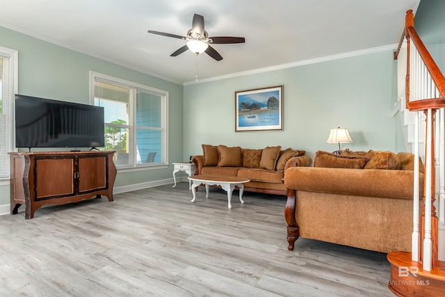 living room featuring baseboards, light wood finished floors, a ceiling fan, and crown molding