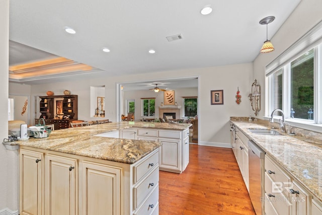 8664 Foxtail Loop, Pensacola, FL 32526 - kitchen with stainless steel dishwasher, cream cabinetry, a sink, a ceiling fan, and light wood-style flooring
