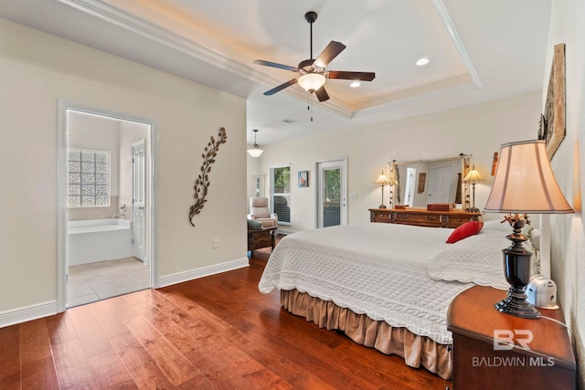 8664 Foxtail Loop, Pensacola, FL 32526 - bedroom featuring wood finished floors, a tray ceiling, baseboards, recessed lighting, and ensuite bathroom