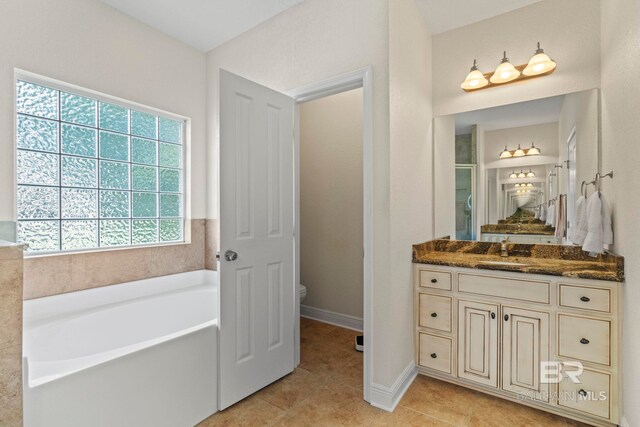 8664 Foxtail Loop, Pensacola, FL 32526 - bathroom with tile patterned floors, toilet, a bath, vanity, and baseboards
