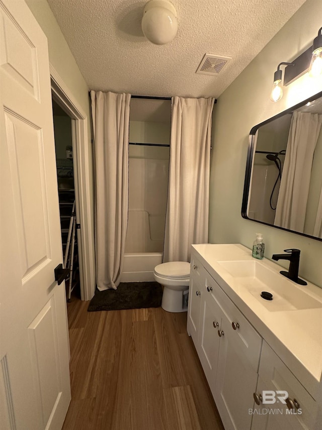 1010 E Hamilton Bridges Dr, Mobile, AL 36695 - full bathroom featuring a textured ceiling, wood finished floors, shower / bath combo, vanity, and toilet