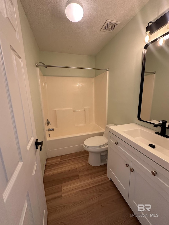1010 E Hamilton Bridges Dr, Mobile, AL 36695 - full bathroom with a textured ceiling, toilet, wood finished floors, vanity, and washtub / shower combination