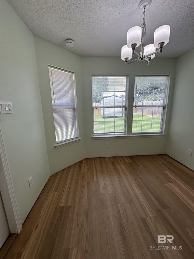 1010 E Hamilton Bridges Dr, Mobile, AL 36695 - unfurnished room featuring a chandelier, plenty of natural light, a textured ceiling, wood finished floors, and a smoke detector