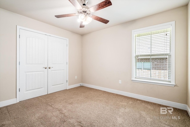 unfurnished bedroom featuring a closet, ceiling fan, and carpet