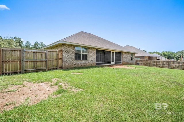 rear view of house featuring a lawn