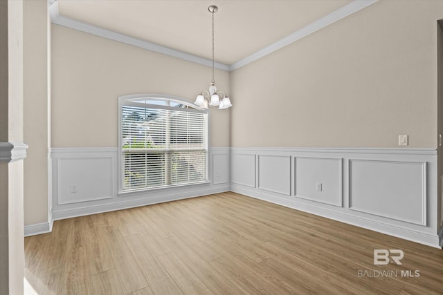 unfurnished dining area featuring crown molding, a notable chandelier, and light wood-type flooring