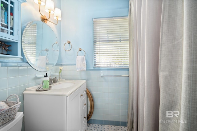 bathroom featuring tile walls, a shower with curtain, vanity, and toilet