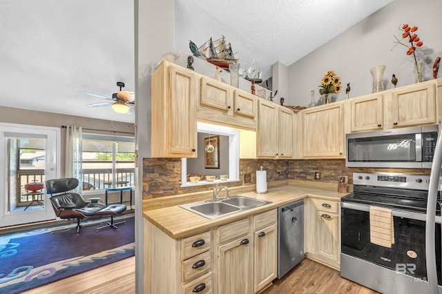 2200 W 2nd St Unit 301-C, Gulf Shores, AL 36542 - kitchen with stainless steel appliances, light brown cabinetry, a textured ceiling, light wood-style floors, and backsplash