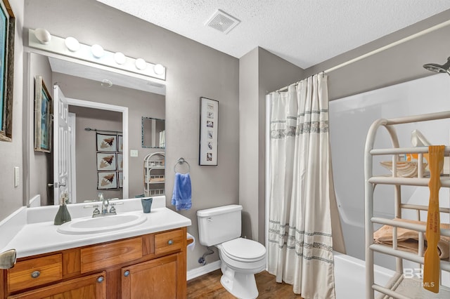 2200 W 2nd St Unit 301-C, Gulf Shores, AL 36542 - full bathroom featuring vanity, shower / bath combo with shower curtain, wood finished floors, and a textured ceiling