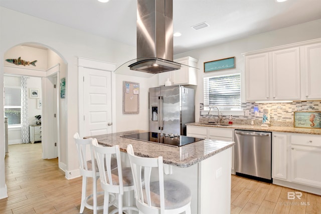 kitchen with island range hood, sink, a kitchen island, white cabinetry, and stainless steel appliances