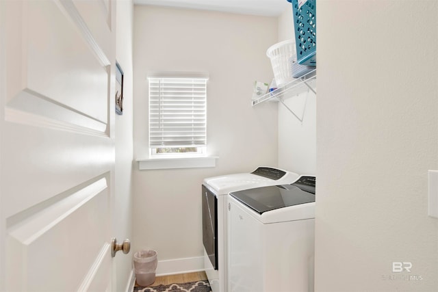 clothes washing area featuring washing machine and dryer and hardwood / wood-style flooring