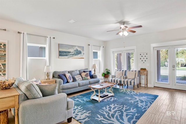 living room with french doors, ceiling fan, plenty of natural light, and wood-type flooring