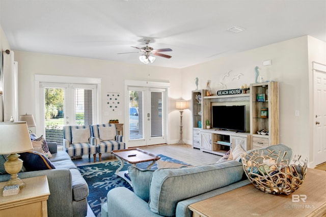 living room featuring ceiling fan, french doors, and light hardwood / wood-style floors