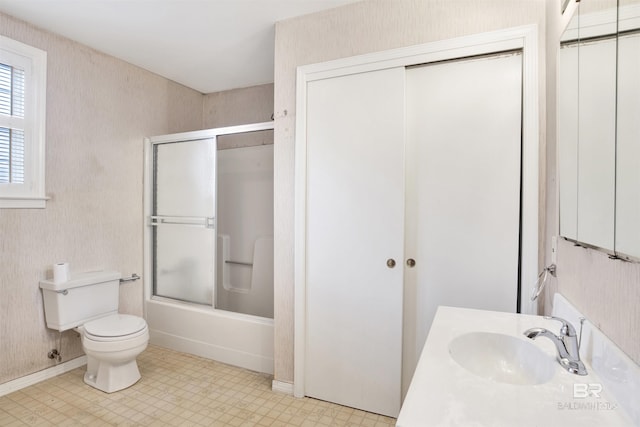 bathroom featuring combined bath / shower with glass door, tile patterned floors, toilet, and vanity