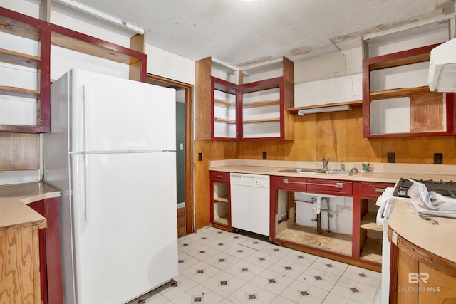 kitchen with wood walls, white appliances, light floors, a sink, and open shelves