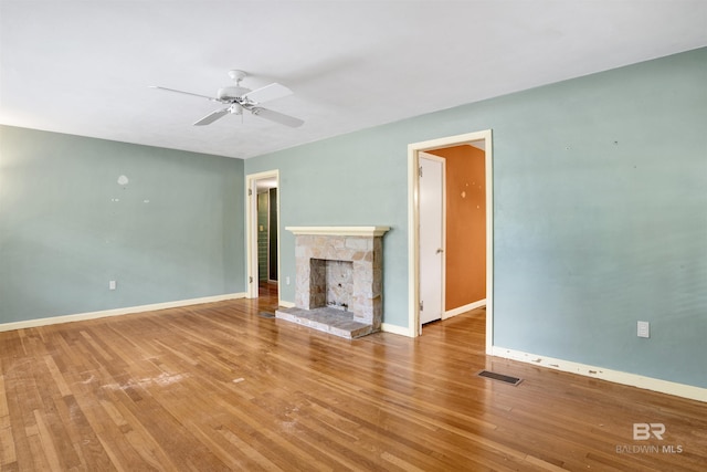 unfurnished living room featuring a ceiling fan, wood finished floors, baseboards, and visible vents