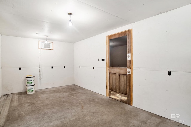 spare room with a wall mounted AC and concrete flooring