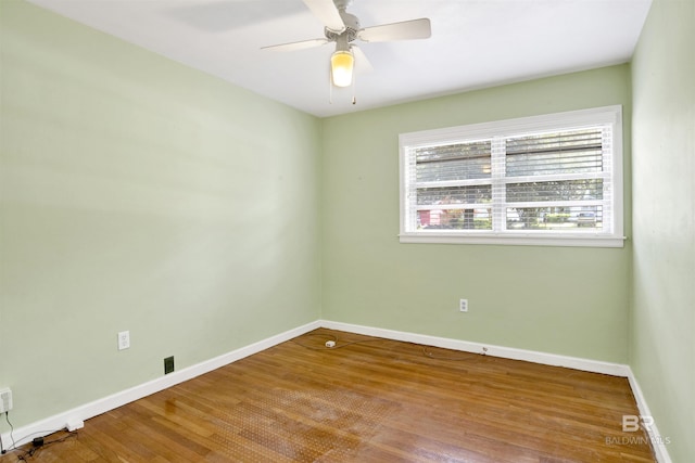 spare room featuring baseboards, ceiling fan, and wood finished floors