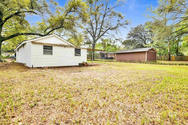 view of yard featuring an outbuilding and fence