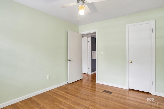 unfurnished bedroom featuring a ceiling fan, visible vents, baseboards, and light wood-type flooring