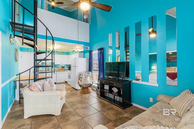 living room with ceiling fan and a high ceiling