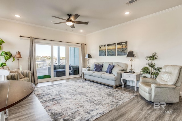 living room featuring ornamental molding, hardwood / wood-style flooring, and ceiling fan