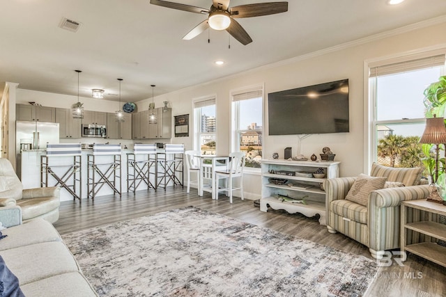 living room featuring ceiling fan, crown molding, and dark hardwood / wood-style floors