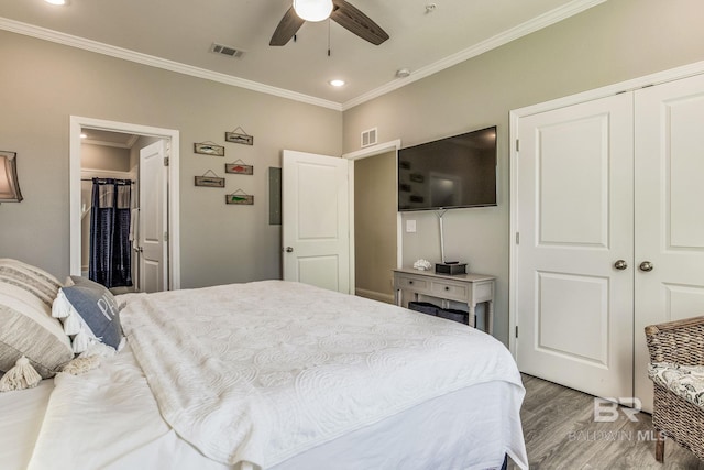 bedroom with a closet, ceiling fan, crown molding, and light hardwood / wood-style flooring