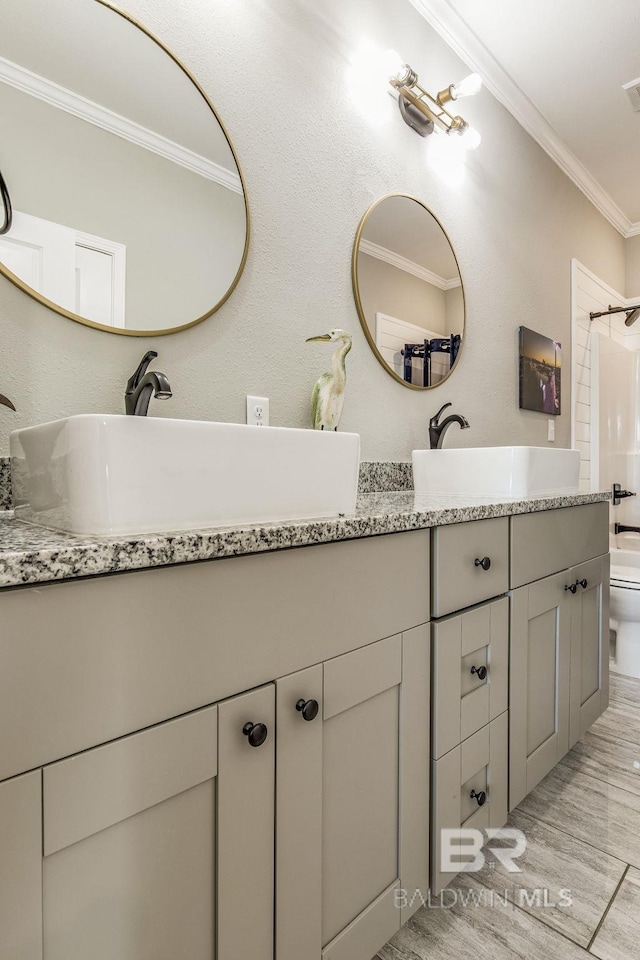 bathroom featuring vanity, toilet, ornamental molding, and walk in shower