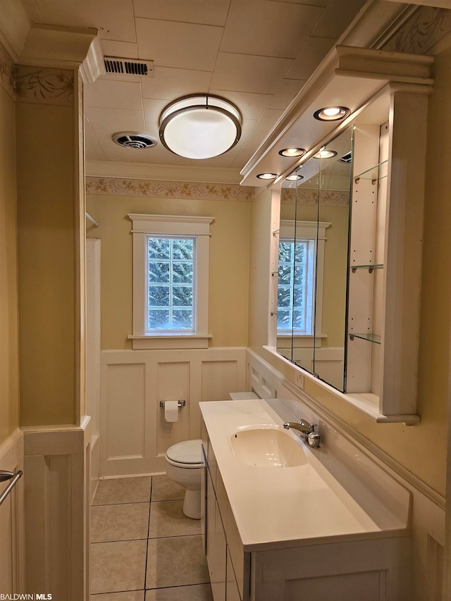 bathroom featuring tile floors, toilet, and vanity with extensive cabinet space