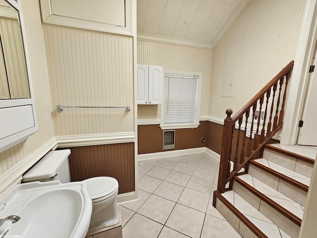 bathroom featuring sink, tile floors, crown molding, and toilet