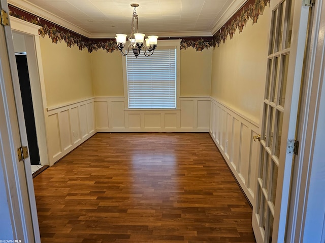 empty room with an inviting chandelier, crown molding, and dark hardwood / wood-style floors