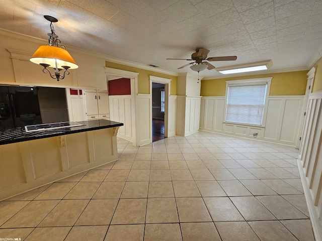 kitchen featuring hanging light fixtures, light tile floors, black appliances, ceiling fan, and ornamental molding