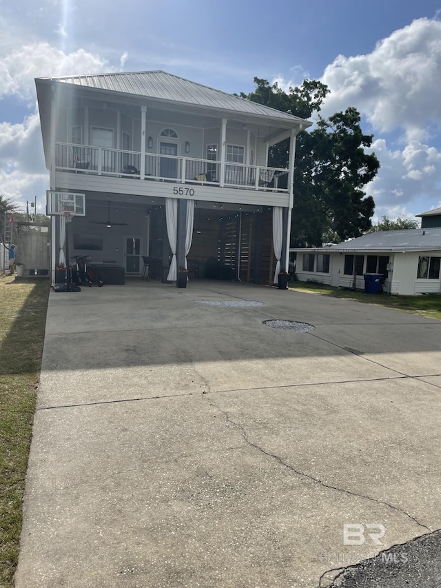 5570 Bay La Launch Ave, Orange Beach, AL 36561 - view of front facade featuring driveway, metal roof, and a balcony