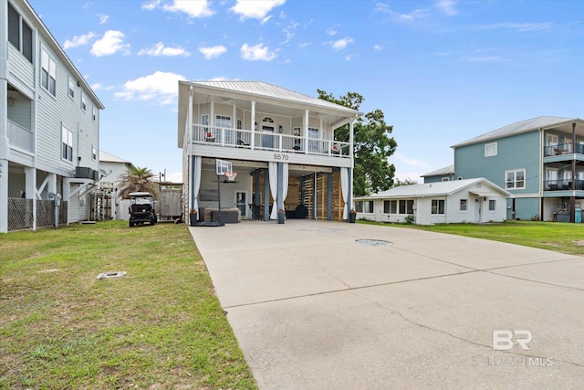 5570 Bay La Launch Ave, Orange Beach, AL 36561 - coastal inspired home with concrete driveway, a front lawn, covered porch, and stairway