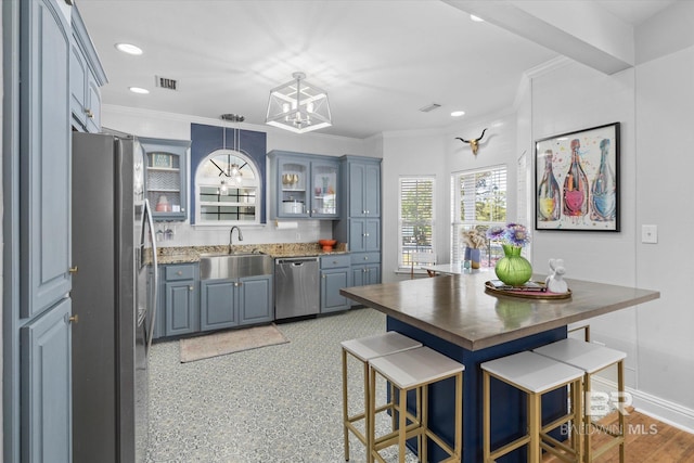 5570 Bay La Launch Ave, Orange Beach, AL 36561 - kitchen featuring appliances with stainless steel finishes, a sink, ornamental molding, glass insert cabinets, and a chandelier