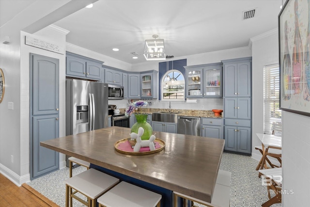 5570 Bay La Launch Ave, Orange Beach, AL 36561 - kitchen featuring stainless steel appliances, a sink, baseboards, glass insert cabinets, and crown molding