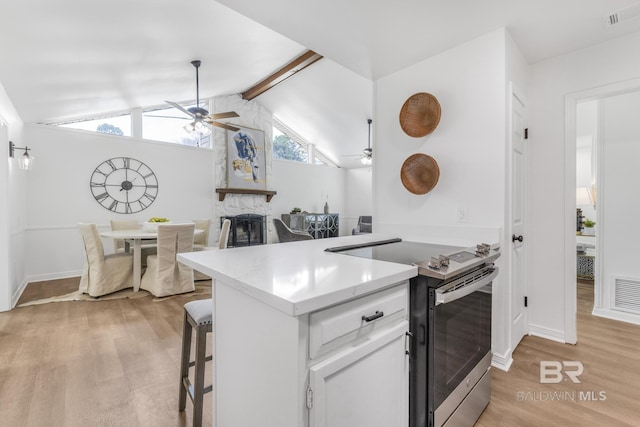 kitchen with light wood finished floors, stainless steel electric range, and ceiling fan