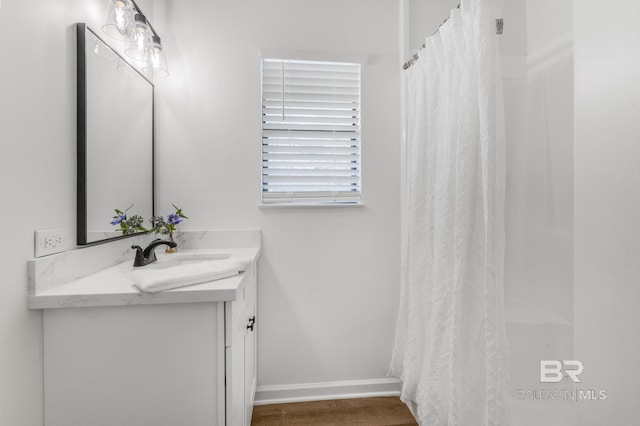 bathroom with vanity, a shower with shower curtain, and baseboards