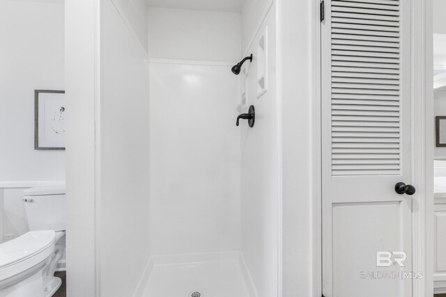 bathroom with a shower stall and toilet