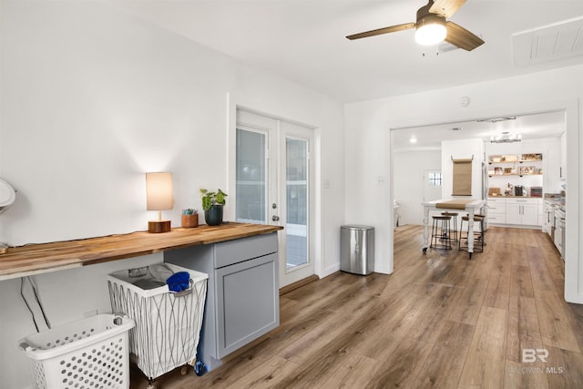 interior space with butcher block counters, visible vents, light wood-style flooring, gray cabinetry, and a ceiling fan